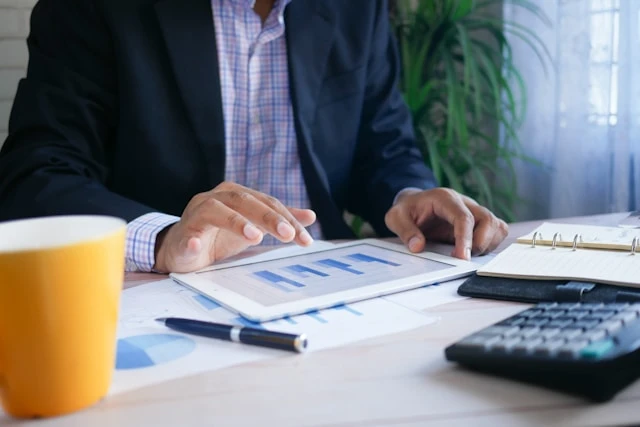 Businessman reviewing charts and a calculator at a desk